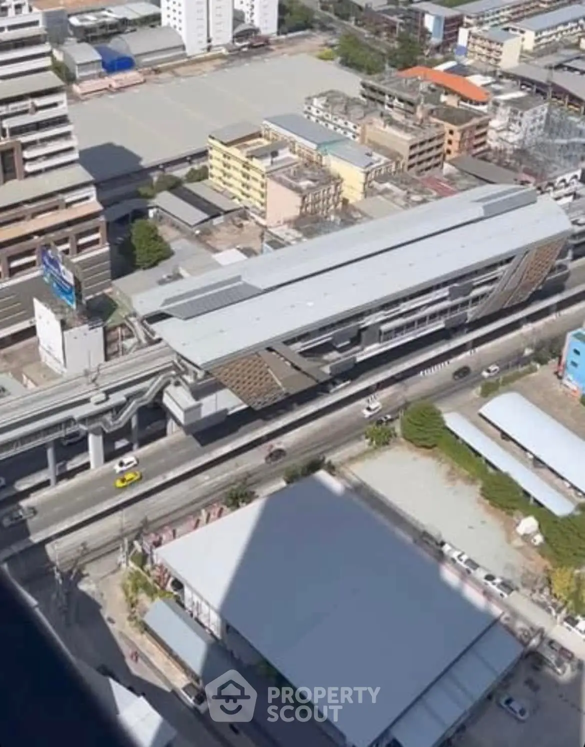 Aerial view of urban cityscape with modern buildings and elevated train station.