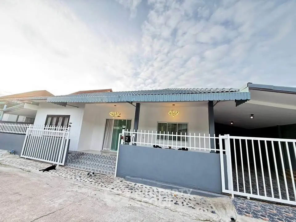 Charming single-story home with modern exterior and gated entrance, perfect for family living.