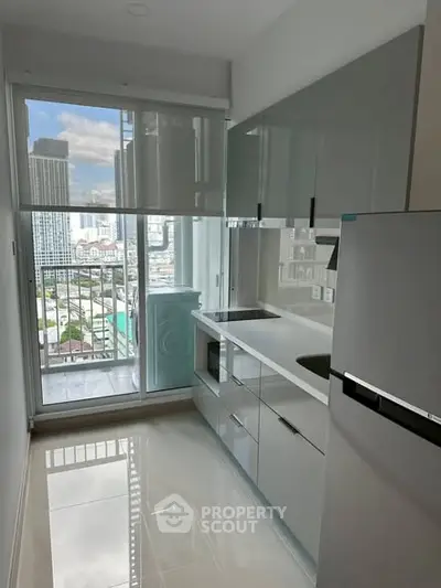 Modern kitchen with sleek cabinets and city view from balcony.