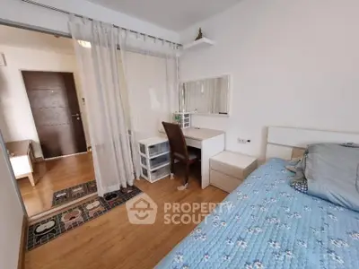 Cozy bedroom with wooden flooring, stylish desk, and comfortable bed in modern apartment.