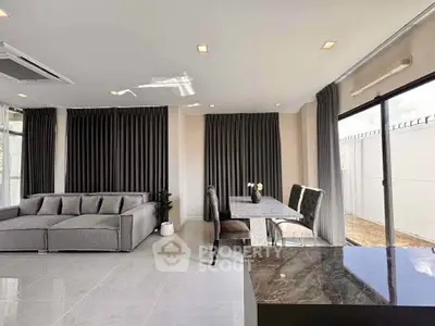 Modern living room with sleek furniture and large windows offering natural light.