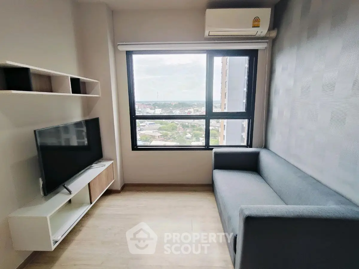 Modern living room with large window and sleek furniture, offering a bright and airy atmosphere.
