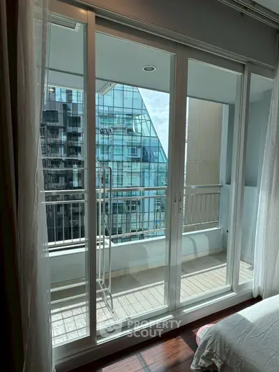 Modern apartment balcony with glass doors and city view