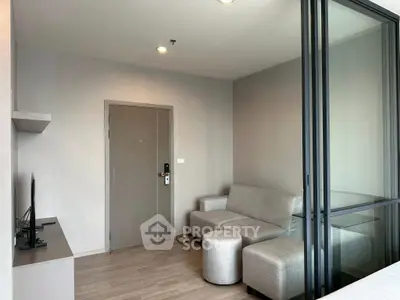 Modern living room with sleek furniture and glass partition in contemporary apartment.