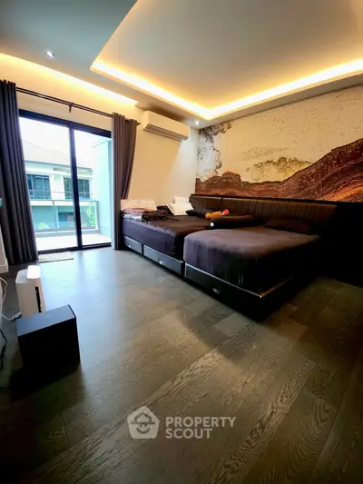 Modern bedroom with stylish decor and balcony access, featuring sleek wood flooring and ambient lighting.