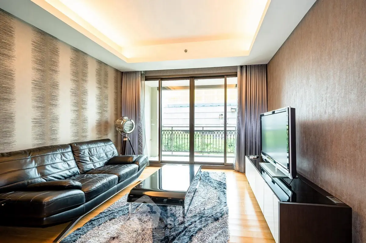 Luxurious living room with modern decor and large windows opening to a balcony.