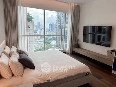 Luxurious bedroom with city view and modern decor in high-rise apartment.
