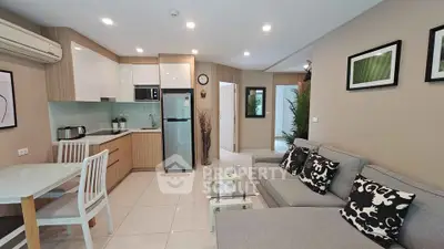 Modern open-plan living room and kitchen with stylish decor and natural light.