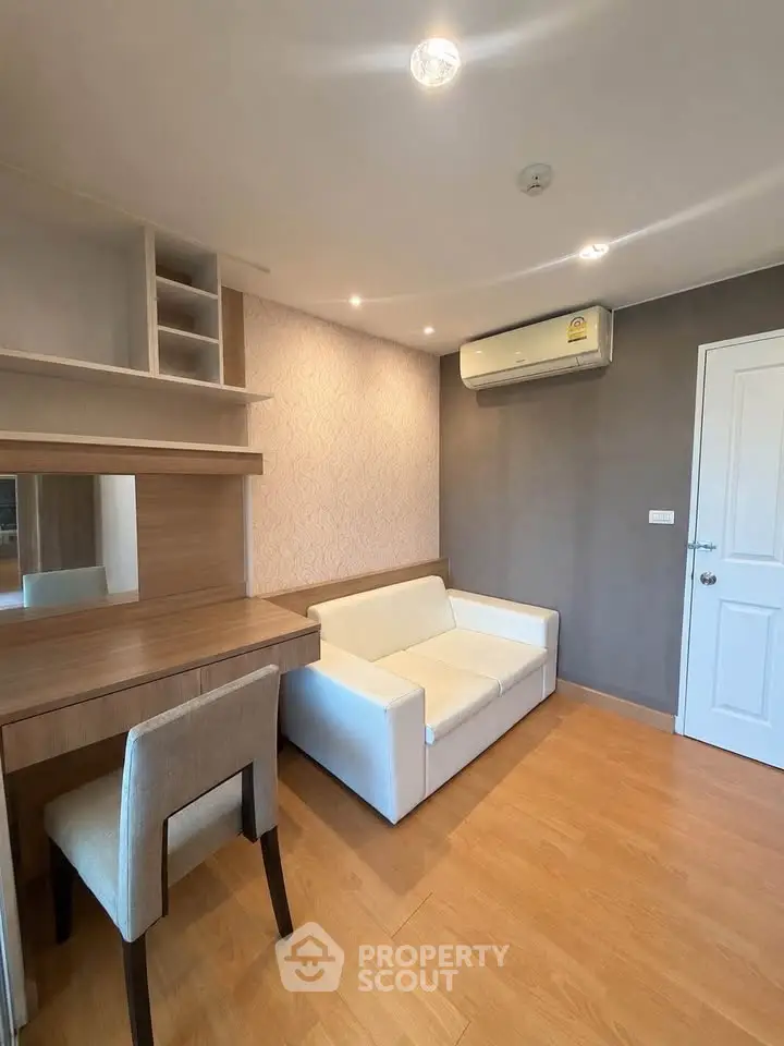 Modern living room with cozy sofa and stylish wooden furniture, featuring air conditioning and elegant lighting.