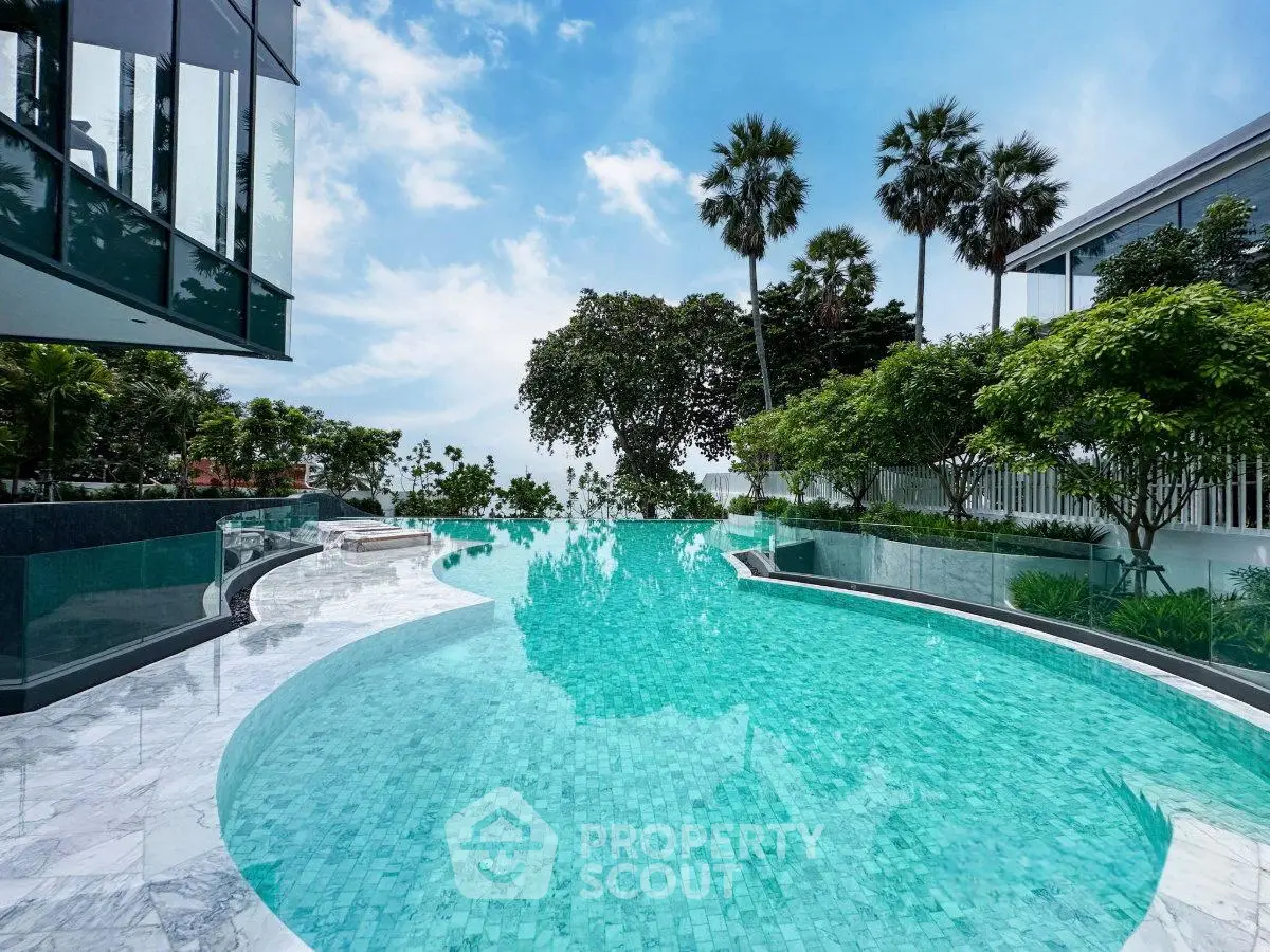 Luxurious infinity pool with stunning views and lush greenery in a modern real estate setting.