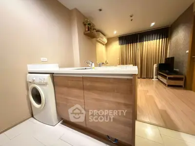 Modern open-plan kitchen and living room with washing machine and stylish decor