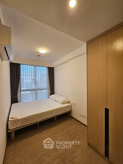 Modern minimalist bedroom with wooden wardrobe and large window