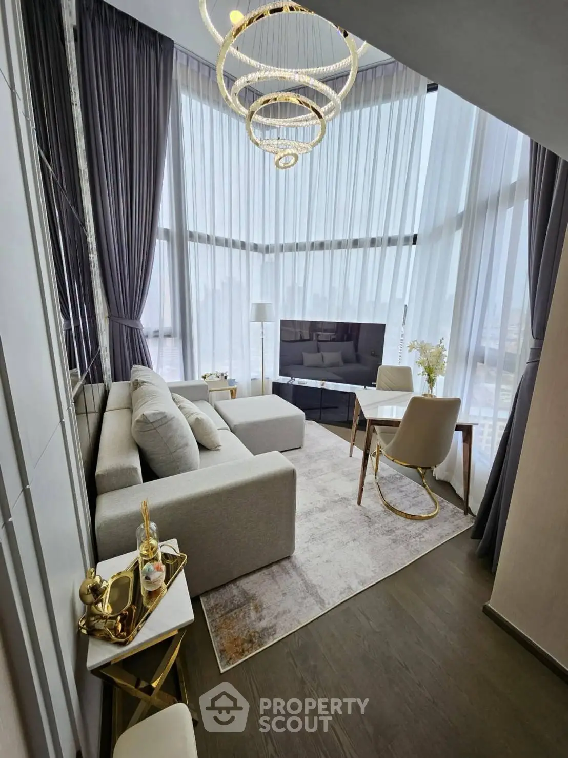 Luxurious high-ceiling living room with modern decor and large windows