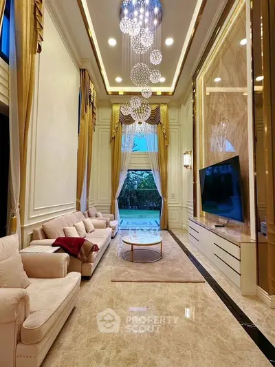 Luxurious high-ceiling living room with elegant chandelier and garden view