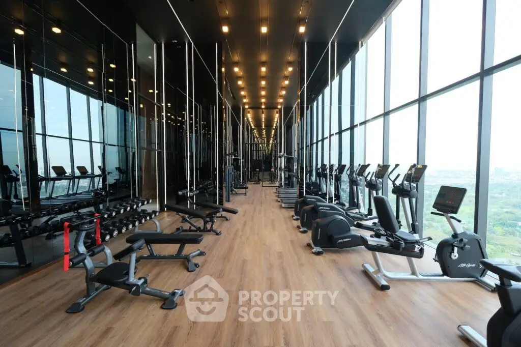 Luxurious high-rise gym with panoramic city views and state-of-the-art fitness equipment.