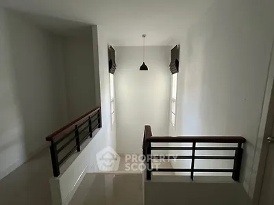 Modern staircase with sleek railing and pendant light in minimalist home interior