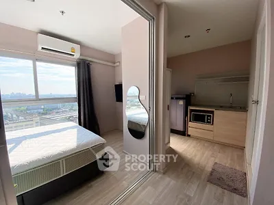 Modern studio apartment with city view, featuring a compact kitchen and cozy bedroom.