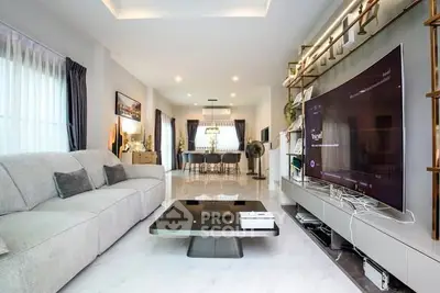 Spacious modern living room with sleek design and large TV, perfect for entertainment.