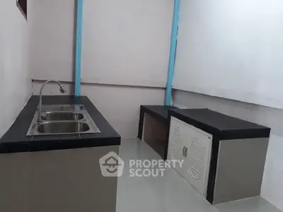 Compact kitchen with sleek countertops and modern sink in minimalist design.