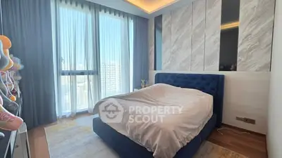 Luxurious bedroom with modern design and large window offering city views.