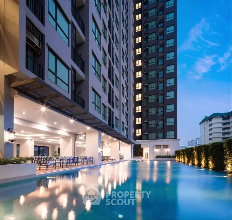 Luxurious high-rise building with stunning poolside view at dusk, perfect for modern urban living.