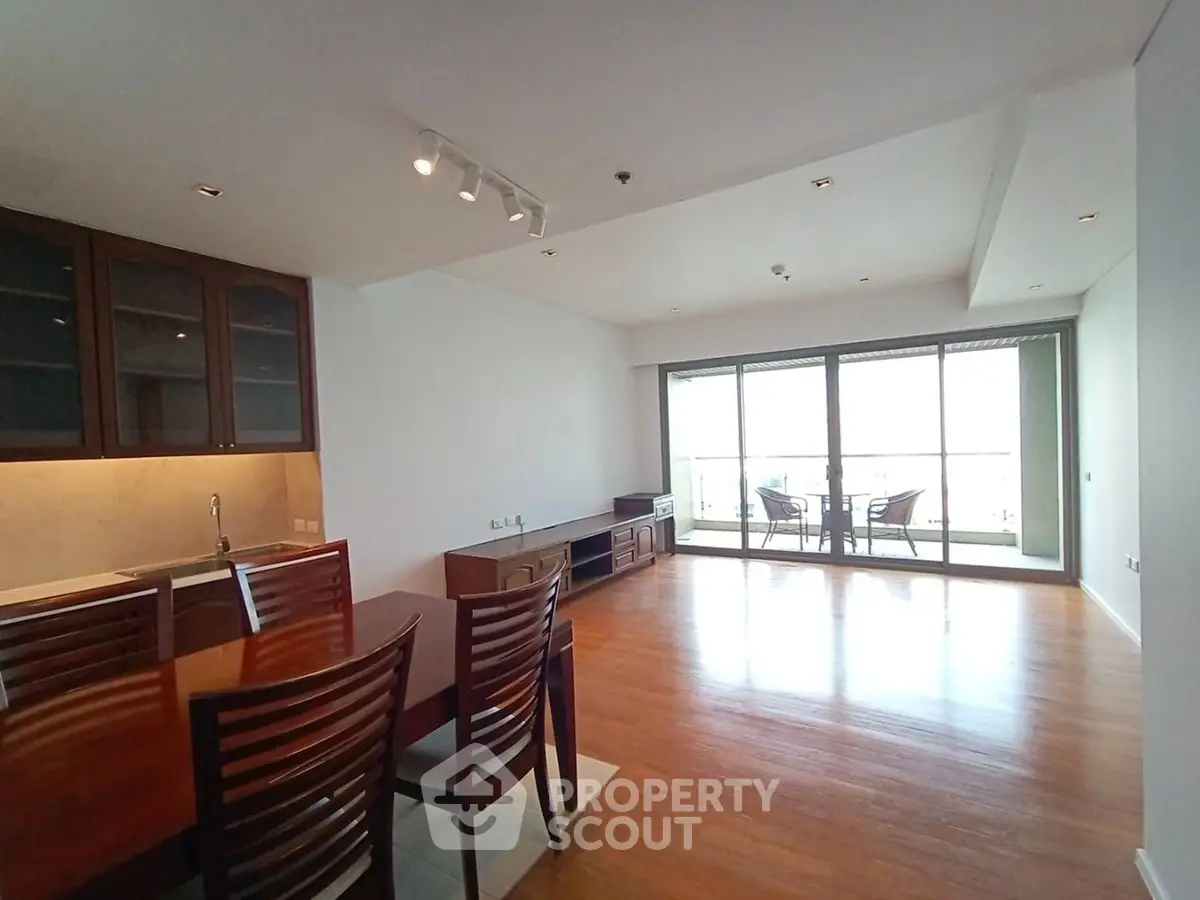 Spacious living room with wooden flooring and large balcony access