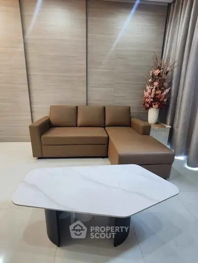 Modern living room with stylish brown sofa and elegant marble coffee table.