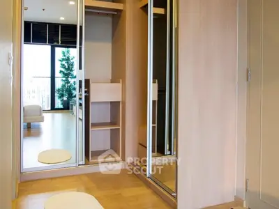 Modern bedroom with mirrored closet and wooden flooring, featuring a spacious and bright interior design.