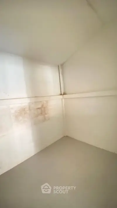 Minimalist storage room with white walls and simple flooring, ideal for organizing essentials.