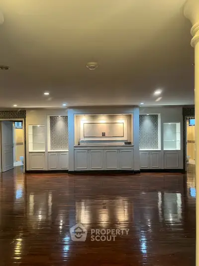 Spacious living room with elegant wooden flooring and built-in cabinetry