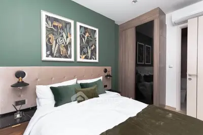 Modern bedroom with stylish decor, green accent wall, and elegant artwork.