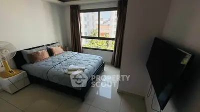Spacious bedroom with modern decor and large window offering city views