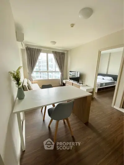 Modern apartment interior with open living and dining area, featuring stylish furniture and large windows.