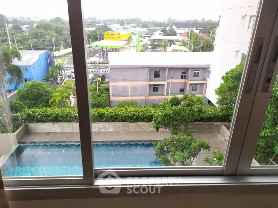 Stunning view of a serene swimming pool from a modern apartment window, perfect for relaxation and leisure.