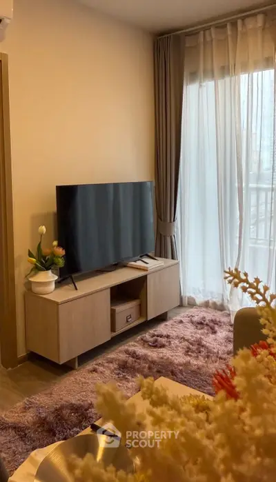 Cozy living room with modern TV setup and plush carpet, perfect for relaxation.