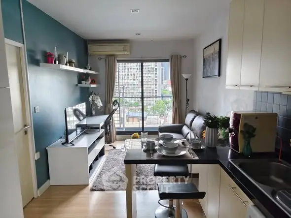 Modern living room with open kitchen and city view, featuring stylish decor and natural light.