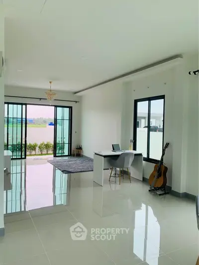 Spacious and bright living room with gleaming floor tiles, large windows, and a serene balcony view, perfect for modern living and entertaining guests.