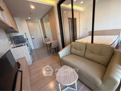 Modern studio apartment with open layout, featuring cozy living area, compact kitchen, and comfortable bed.