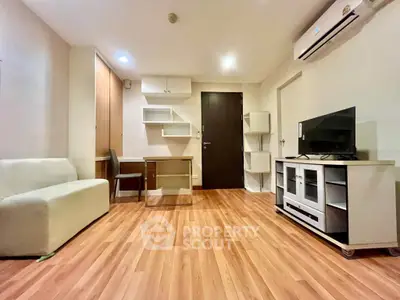 Modern living room with wooden flooring, sleek furniture, and air conditioning unit.