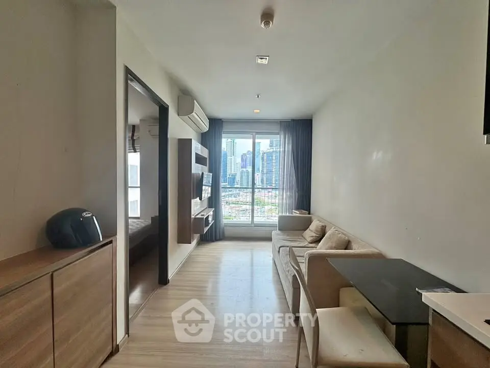 Modern living room with city view, featuring sleek furniture and natural light.