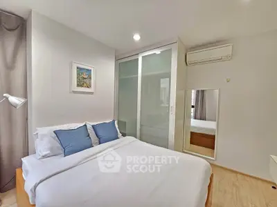 Cozy bedroom with modern decor and ample storage space in a stylish apartment.