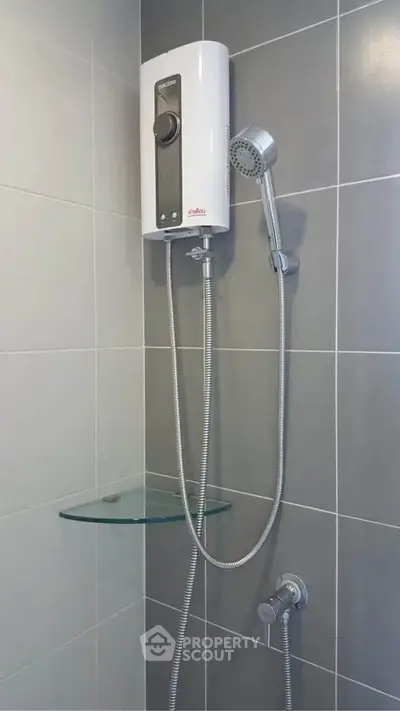 Modern bathroom with sleek shower unit and glass shelf, perfect for contemporary living.