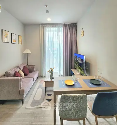 Modern living room with stylish decor and natural light, featuring a cozy sofa and dining area.