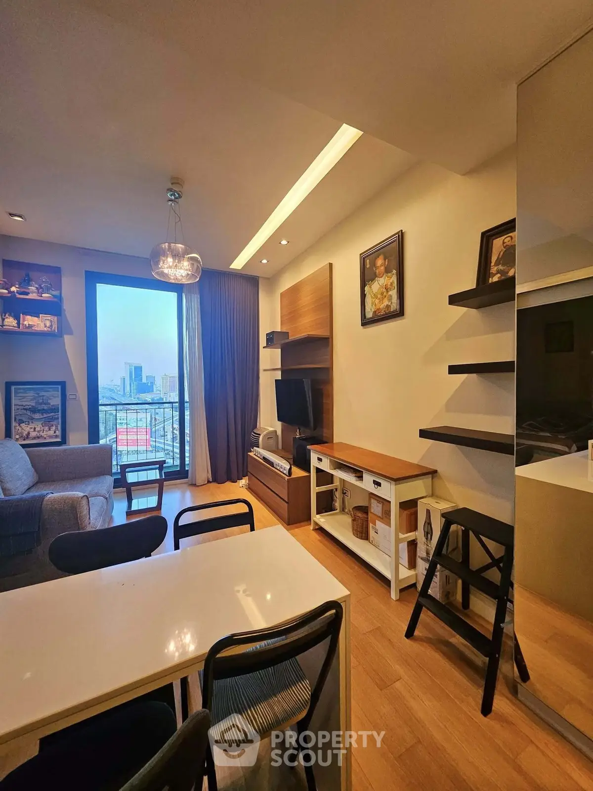 Modern living room with city view, stylish decor, and cozy seating area in a high-rise apartment.