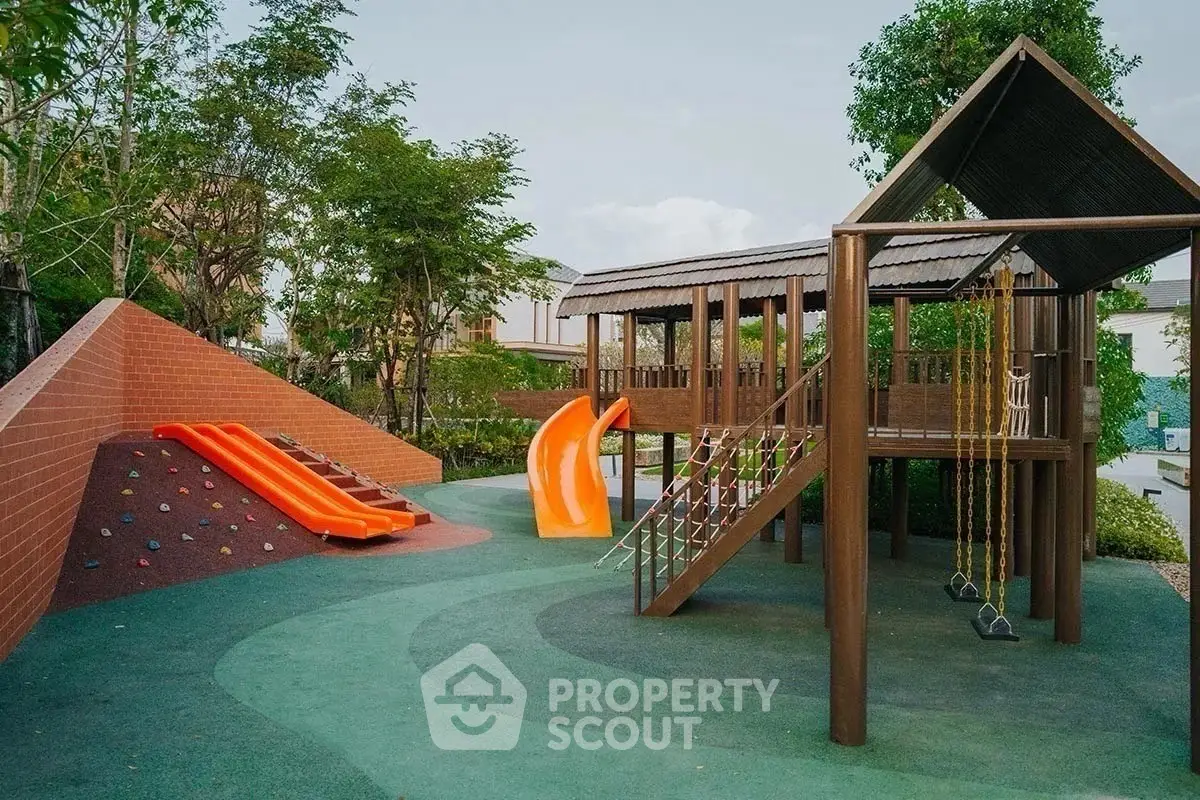 Charming residential playground with slides and climbing area surrounded by lush greenery.