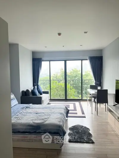 Modern studio apartment with large windows and balcony view, featuring cozy bed and stylish living area.