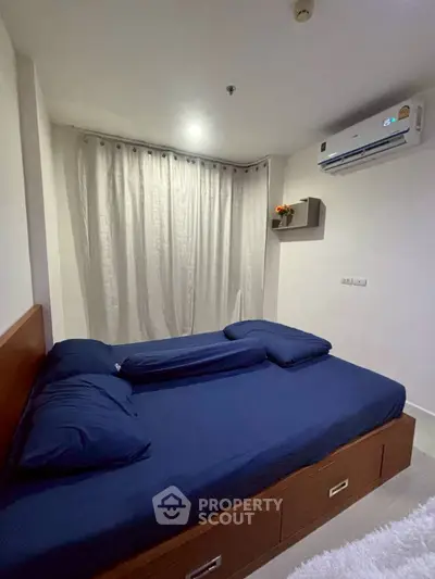 Cozy bedroom with blue bedding and air conditioning, perfect for relaxation.