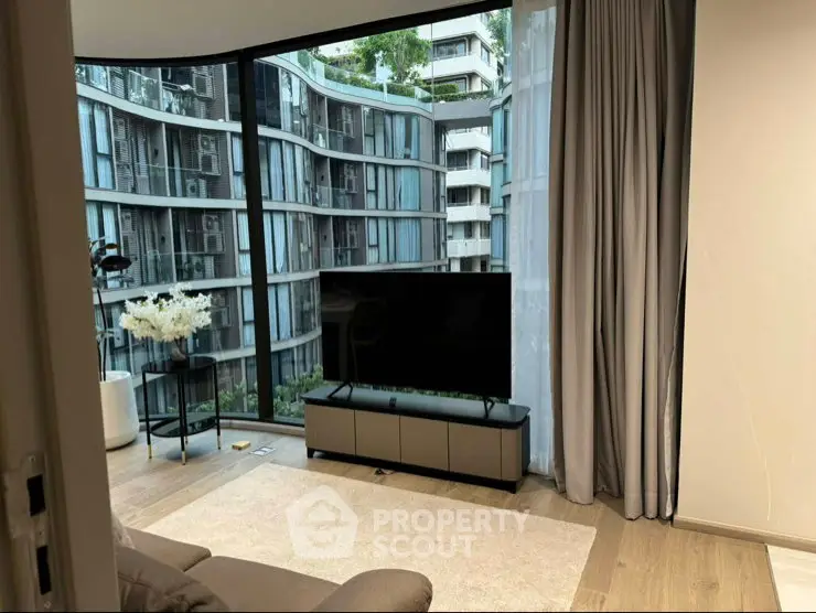 Modern living room with floor-to-ceiling windows offering stunning cityscape views.