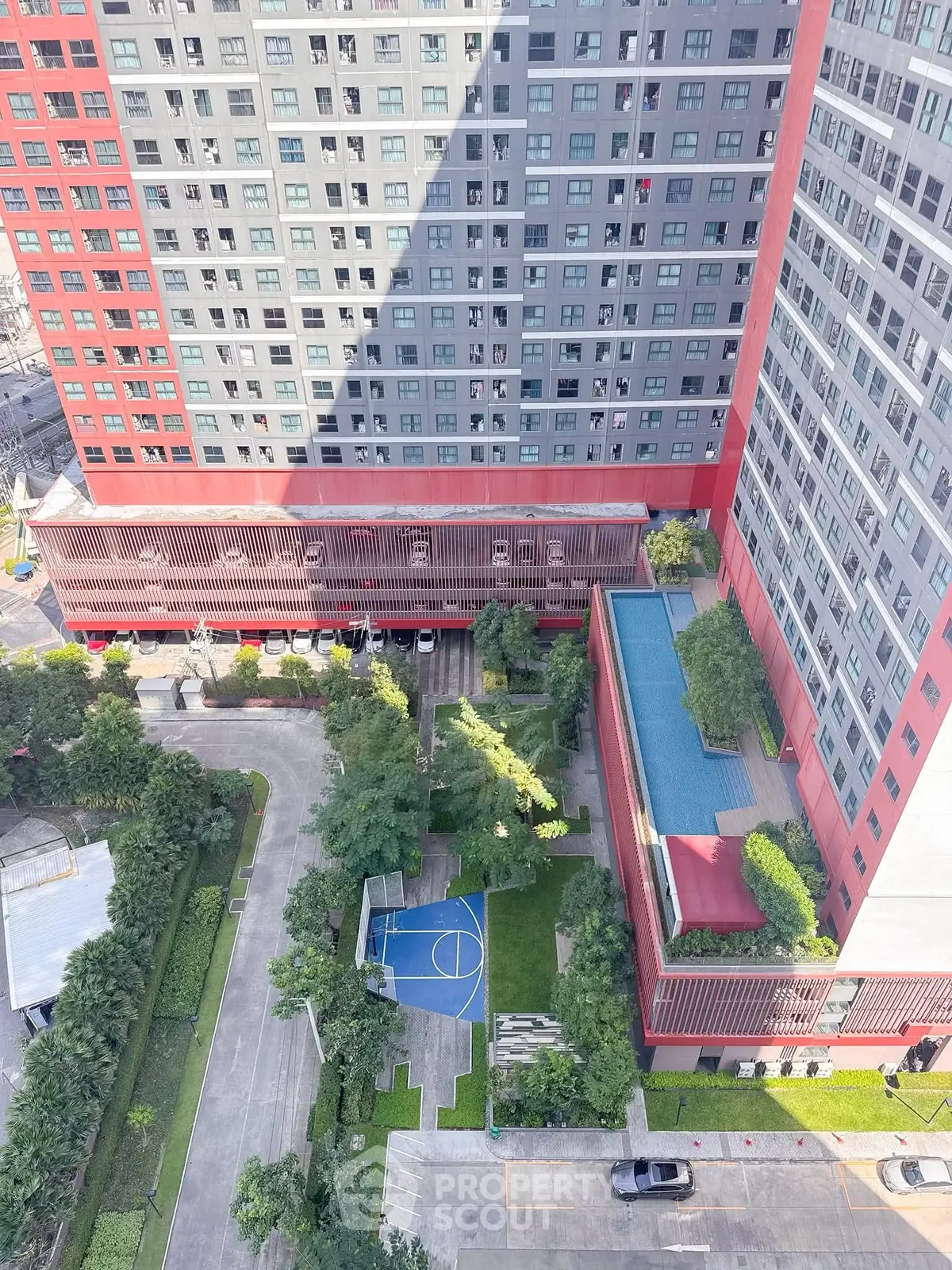 Stunning aerial view of modern high-rise building with pool and basketball court