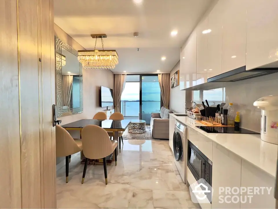 Luxurious open-plan living room with ocean view, modern kitchen, and elegant dining area.